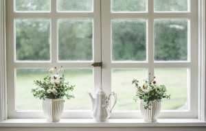 Charming window with white trim allowing natural light to brighten a cozy renovated living space.