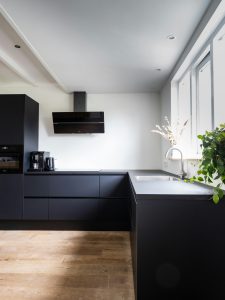 Modern renovated kitchen with stove-top fan and quartz countertops in a rental property.